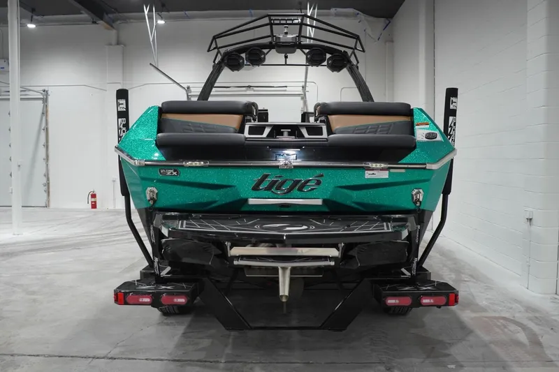 Slide: The Image of 2024 Tigé Ultré 25ZX boat in a showroom, showcasing sleek design and vibrant color. - 76