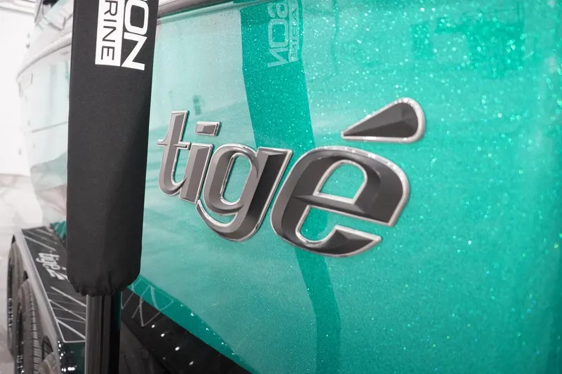 Slide: The Image of 2024 Tigé Ultré 25ZX boat with teal metallic finish and logo detail. - 78