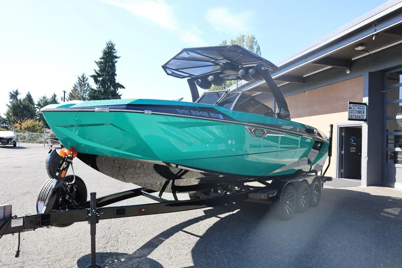 Slide: The Image of 2024 Tigé Ultré 25ZX boat on trailer, vibrant teal color, parked outdoors. - 8