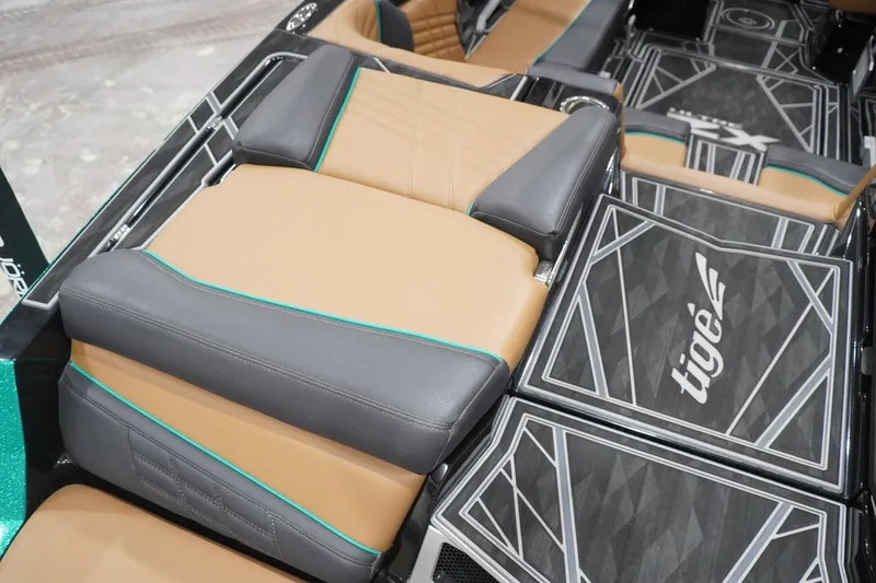Slide: The Image of 2024 Tigé Ultré 25ZX boat interior with tan and gray seating, geometric flooring design. - 82