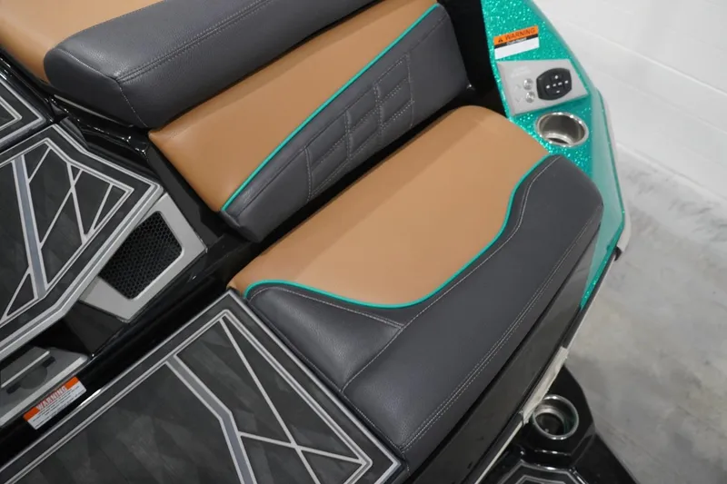 Slide: The Image of 2024 Tigé Ultré 25ZX boat interior with stylish brown and black seating, teal accents, and cup holder. - 85