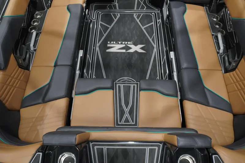 Slide: The Image of 2024 Tigé Ultré 25ZX boat interior with luxurious tan and black seating. - 90