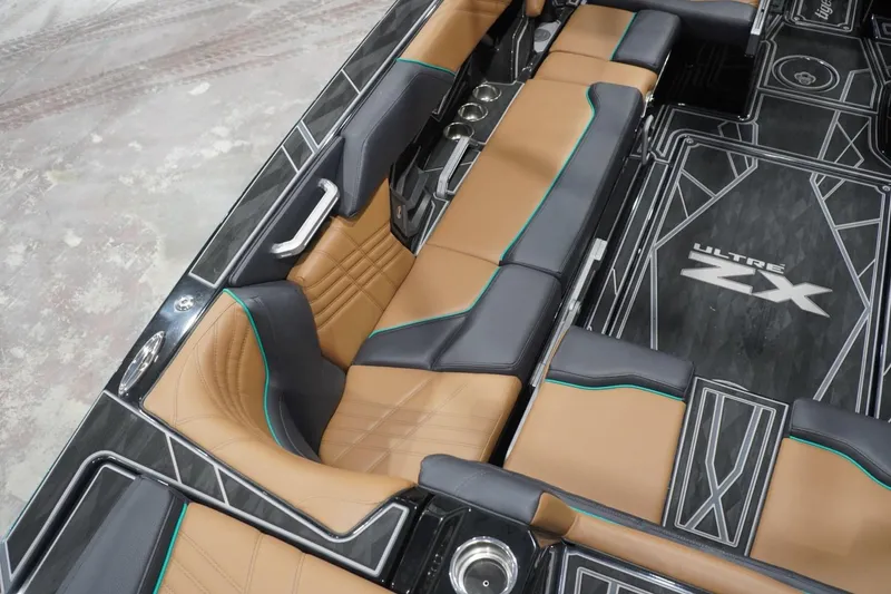 Slide: The Image of 2024 Tigé Ultré 25ZX boat interior with tan and black seating, stylish design. - 91