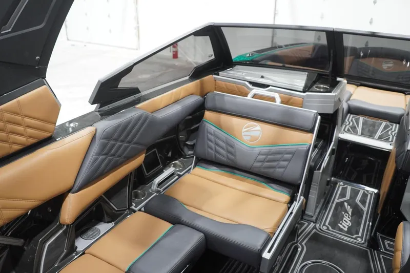 Slide: The Image of 2024 Tigé Ultré 25ZX boat interior with luxurious tan and black seating. - 96