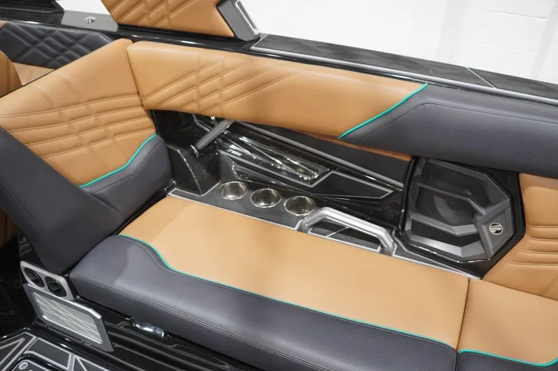Slide: The Image of 2024 Tigé Ultré 25ZX interior with tan and black seating, teal accents, and cup holders. - 99