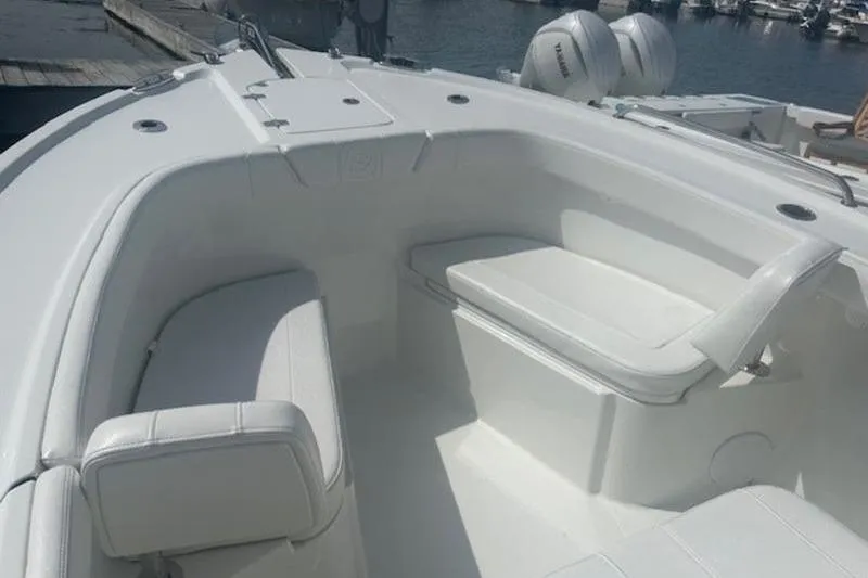 Slide: The Image of 2025 Parker 2200 Center Console boat interior with white seating, docked at marina. - 13