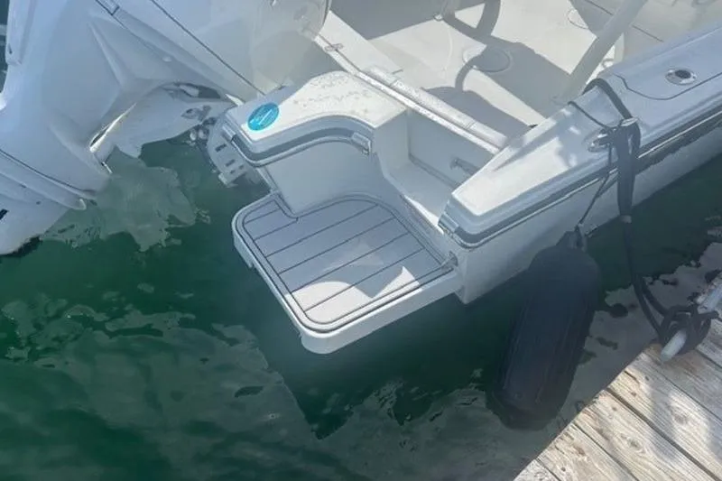 Slide: The Image of 2025 Parker 2200 Center Console boat with outboard motor, docked on calm water. - 14