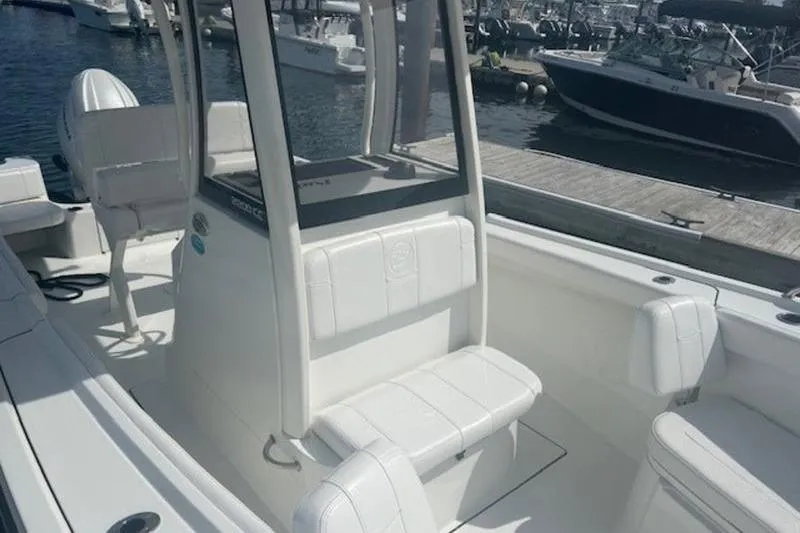 Slide: The Image of 2025 Parker 2200 Center Console boat docked at marina, featuring sleek white seating. - 9