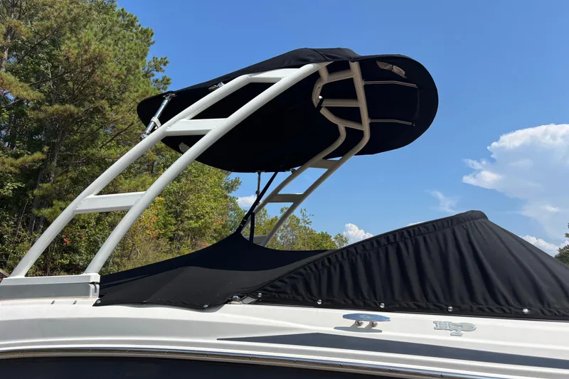 Slide: The Image of 2019 Chaparral 21 H2O Sport boat with black canopy against blue sky. - 3
