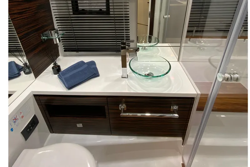 Slide: The Image of Luxurious bathroom interior of 2026 Cobrey 33 HT yacht with modern glass sink and sleek design. - 10