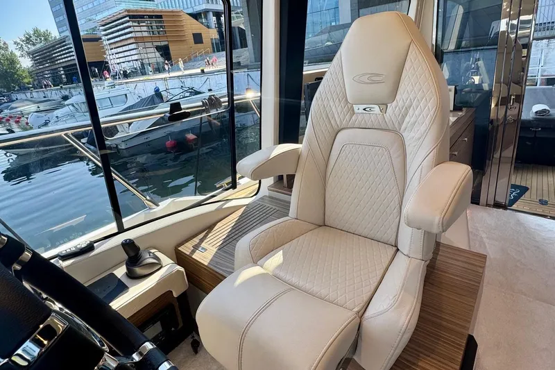 Slide: The Image of Luxurious interior of 2026 Cobrey 45 FLY yacht with elegant captain's chair and marina view. - 8