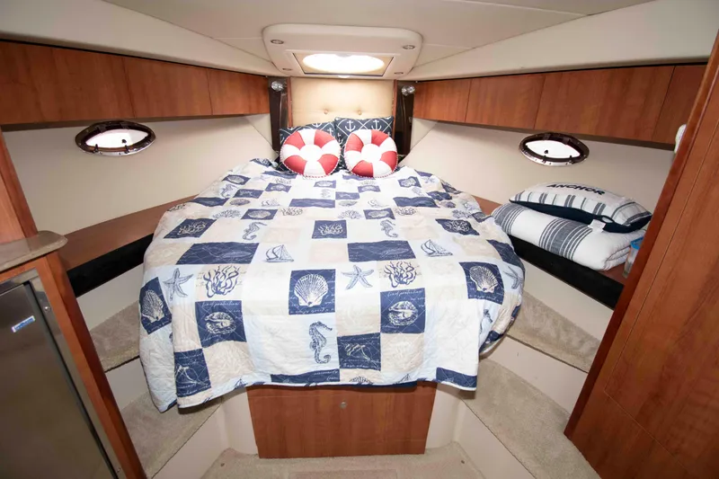 Slide: The Image of 2011 Cruisers Yachts 360 Express cabin with nautical-themed bedding and wooden interior. - 14