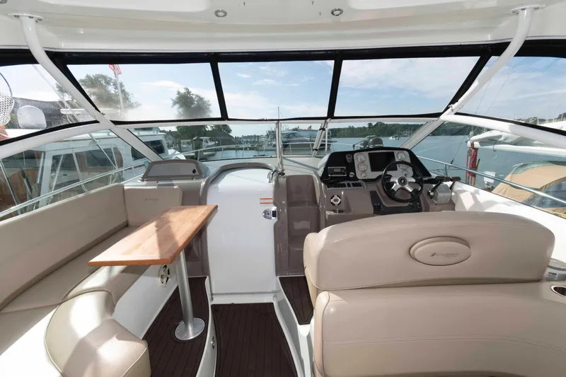 Slide: The Image of 2011 Cruisers Yachts 360 Express interior with helm, seating, and table, docked at marina. - 4