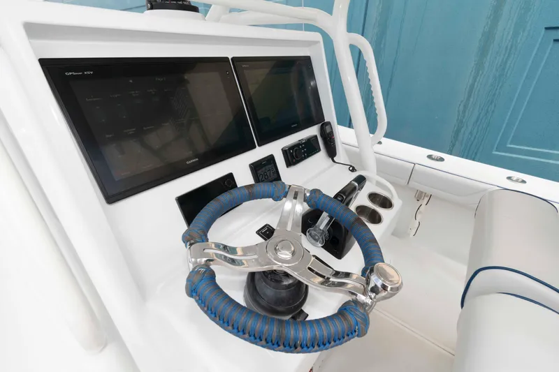 Slide: The Image of 2018 Yellowfin 32 Offshore boat dashboard with steering wheel and navigation screens. - 10