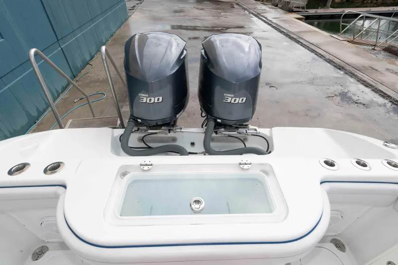 Slide: The Image of 2018 Yellowfin 32 Offshore boat with dual Yamaha 300 engines, docked on wet pavement. - 14