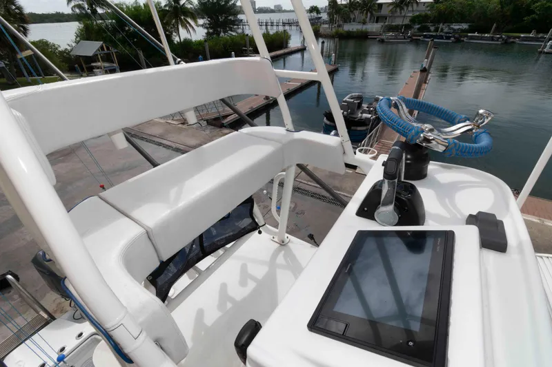 Slide: The Image of 2018 Yellowfin 32 Offshore boat helm with steering wheel and control panel, docked by the water. - 16