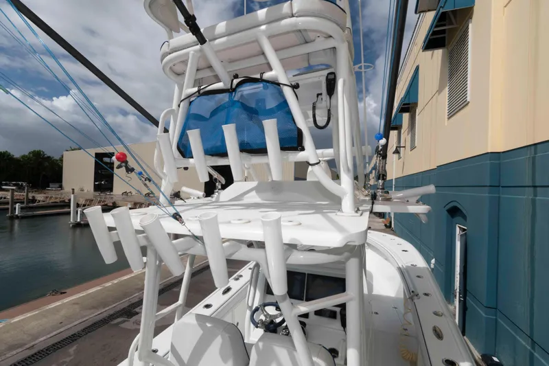 Slide: The Image of 2018 Yellowfin 32 Offshore boat with rod holders, docked near a building. - 19