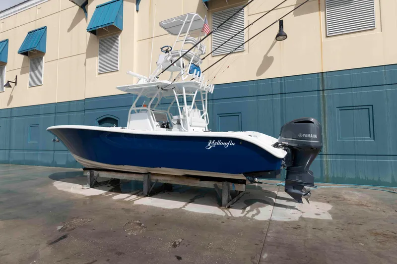 Slide: The Image of 2018 Yellowfin 32 Offshore boat with Yamaha engine, docked near a building. - 2