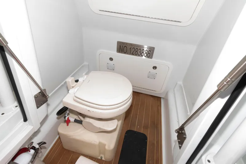 Slide: The Image of 2018 Yellowfin 32 Offshore boat bathroom with toilet and wooden flooring. - 26