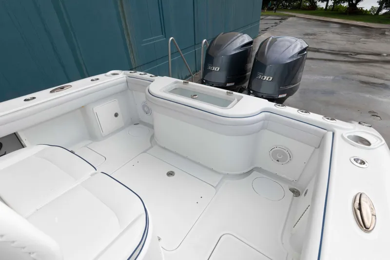 Slide: The Image of 2018 Yellowfin 32 Offshore boat interior with dual 300 horsepower engines, white seating, and storage compartments. - 5