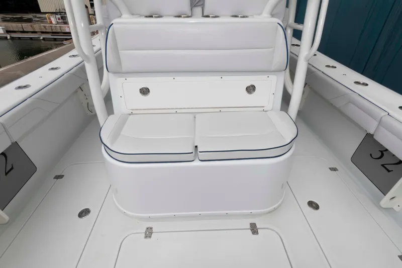 Slide: The Image of 2018 Yellowfin 32 Offshore boat interior with cushioned seating and storage compartment. - 7