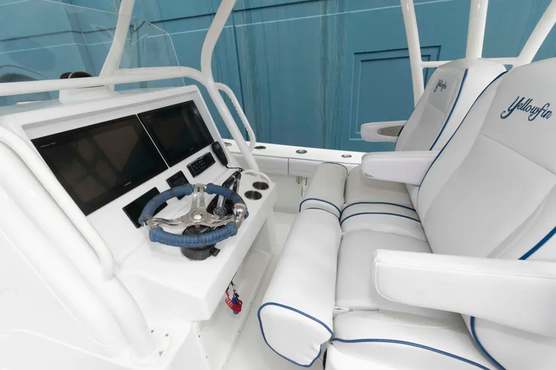 Slide: The Image of 2018 Yellowfin 32 Offshore boat interior with dual screens and cushioned seating. - 8