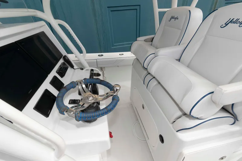 Slide: The Image of 2018 Yellowfin 32 Offshore boat interior with steering wheel and dual seats. - 9