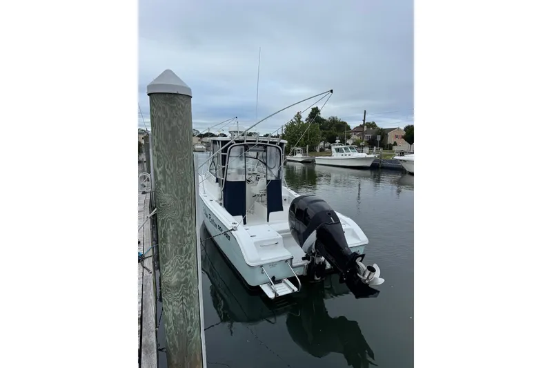 Slide: The Image of 2006 Sea Pro 238 Walk Around boat docked in a marina, rear view. - 3