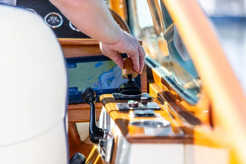 Slide: The Image of Hand operating controls on a 2003 Hinckley T29R boat dashboard. - 10