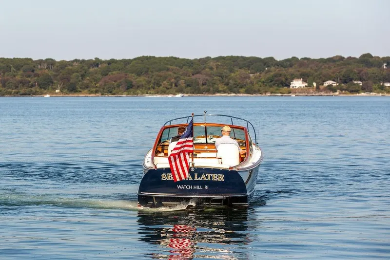 Slide: The Image of 2003 Hinckley T29R boat cruising on calm water with American flag. - 16