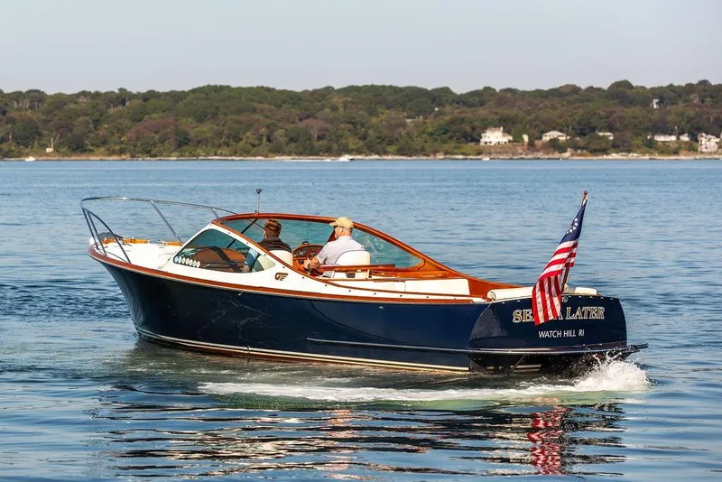 Slide: The Image of 2003 Hinckley T29R boat cruising on calm water with American flag. - 17