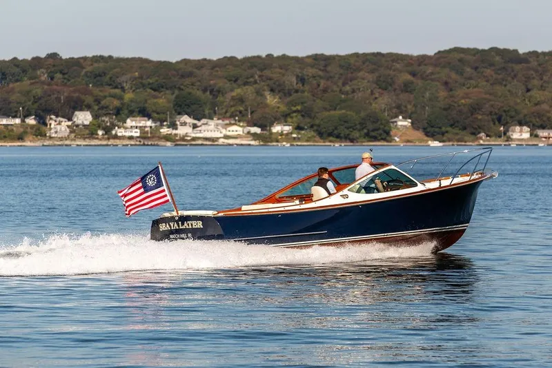 Slide: The Image of 2003 Hinckley T29R boat cruising on a calm lake with passengers onboard. - 20