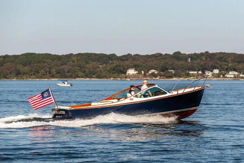 Slide: The Image of 2003 Hinckley T29R boat cruising on a sunny day with American flag. - 28