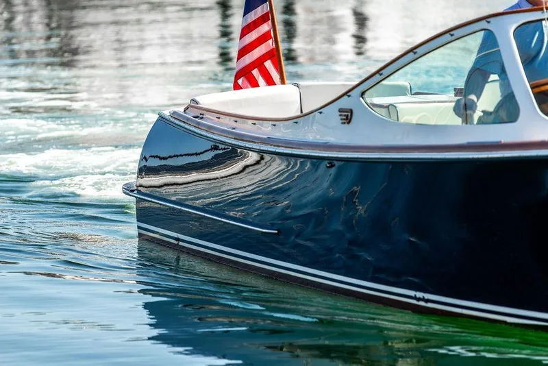 Slide: The Image of 2003 Hinckley T29R boat with American flag on calm water. - 30