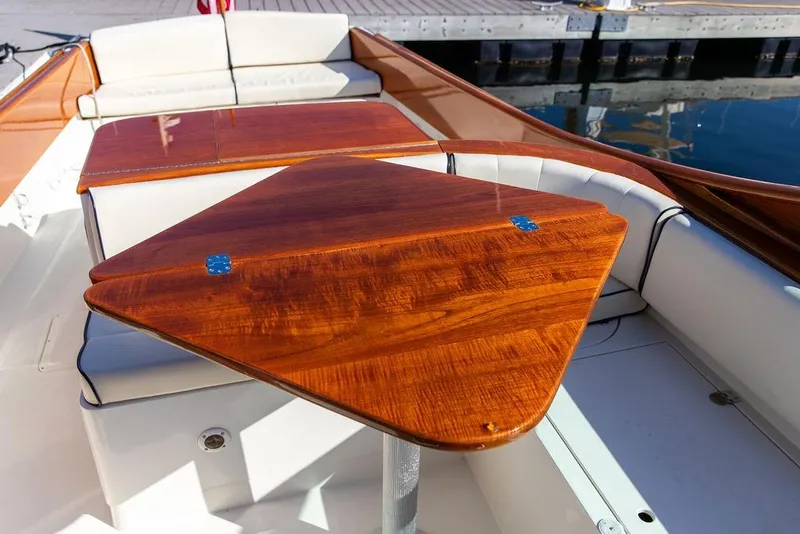 Slide: The Image of 2003 Hinckley T29R boat interior with polished wooden table and white seating. - 32