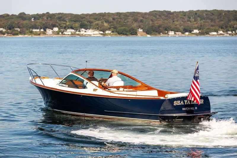 Slide: The Image of 2003 Hinckley T29R boat cruising on a calm lake with American flag. - 4