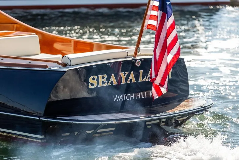 Slide: The Image of Hinckley T29R 2003 boat with American flag, named "Sea Ya Later," on water. - 6