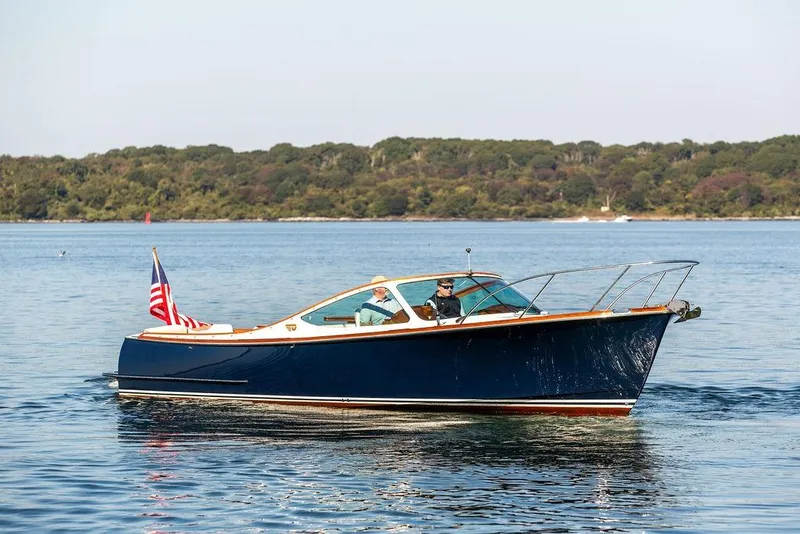 Slide: The Image of 2003 Hinckley T29R boat cruising on calm water with scenic forest backdrop. - 13