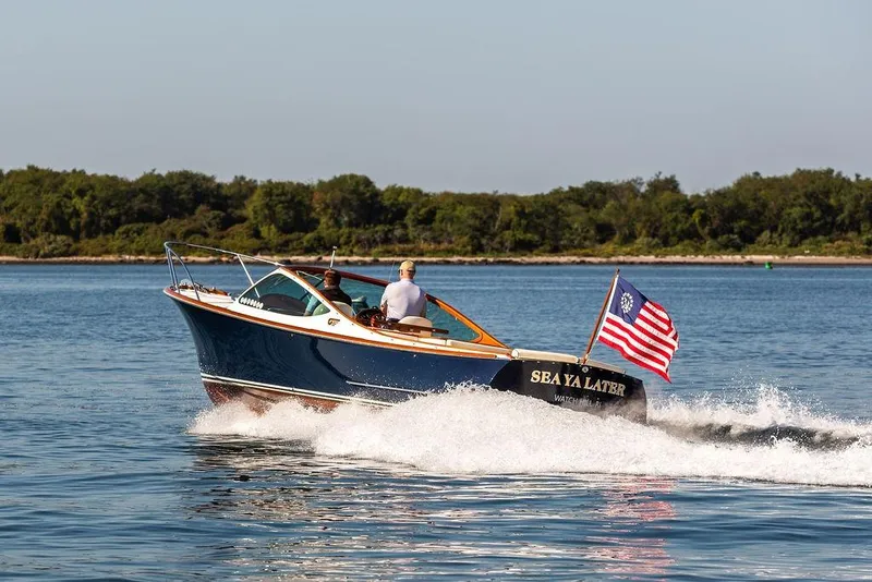 Slide: The Image of 2003 Hinckley T29R boat cruising on water with American flag. - 25