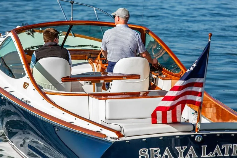 Slide: The Image of 2003 Hinckley T29R boat on water with two people and American flag. - 5
