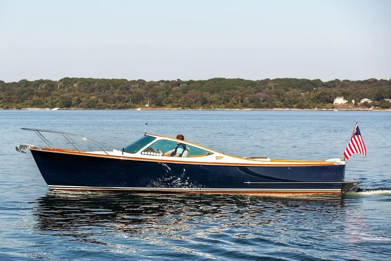 Slide: The Image of 2003 Hinckley T29R boat cruising on calm water with American flag. - 7