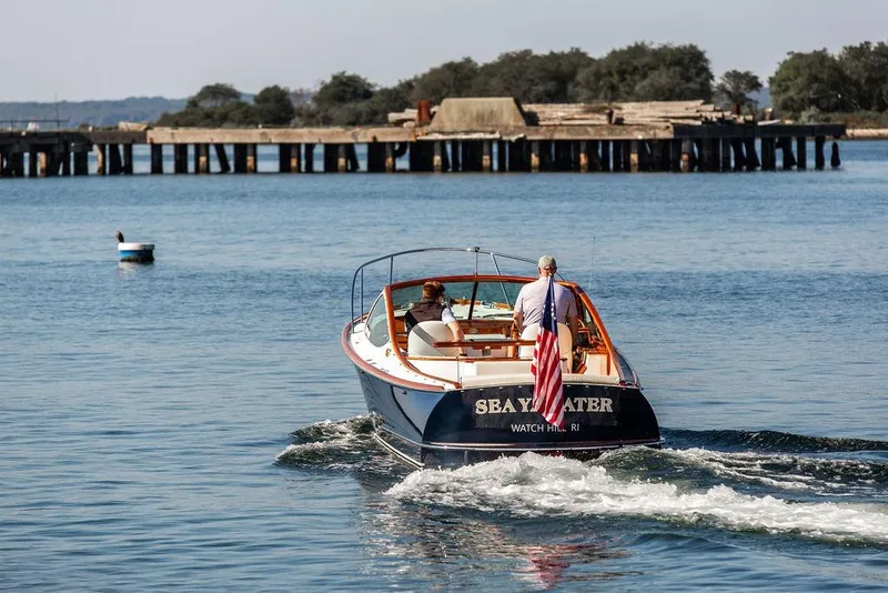 Slide: The Image of Hinckley T29R boat from 2003 cruising on calm waters near a pier. - 8