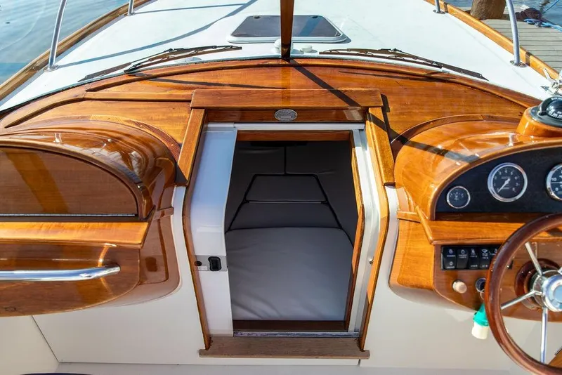Slide: The Image of 2003 Hinckley T29R boat interior with polished wood dashboard and open cabin entrance. - 9