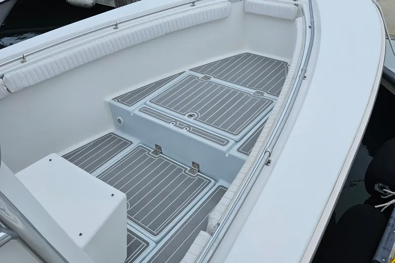 Slide: The Image of 2005 Topaz 24 Silverhawk boat interior with cushioned seating and sleek deck design. - 10