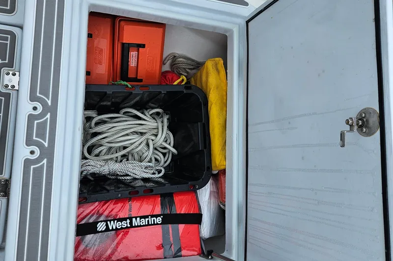 Slide: The Image of Storage compartment in a 2005 Topaz 24 Silverhawk boat with marine gear and ropes. - 13