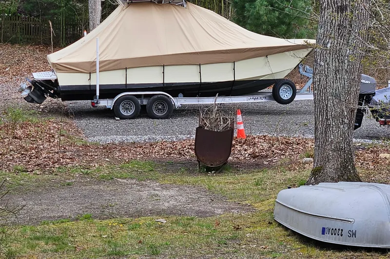 Slide: The Image of Covered 2005 Topaz 24 Silverhawk boat on trailer in wooded area. - 2