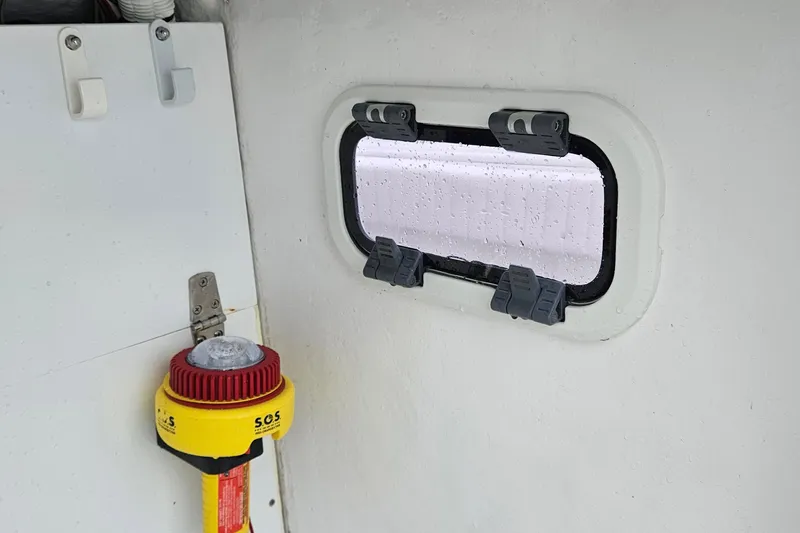 Slide: The Image of Interior of 2005 Topaz 24 Silverhawk boat with window and SOS device. - 27