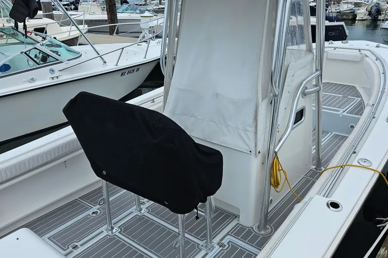 Slide: The Image of 2005 Topaz 24 Silverhawk boat interior with covered seating and docked in a marina. - 4