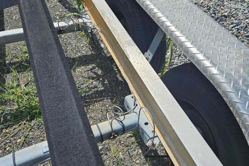 Slide: The Image of Trailer frame and wheels of a 2005 Topaz 24 Silverhawk boat on gravel. - 40