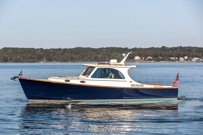 Slide: The Image of 2017 Hinckley Picnic Boat MKIII cruising on calm waters near a wooded shoreline. - 1
